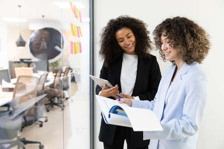 Happy business women sitting in a couch in the office and working together. Office concept.