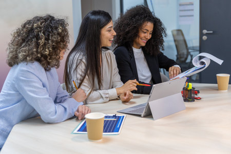 Happy business women having a meeting in the office and looking at graphics.の写真素材