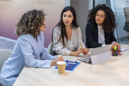 Happy business women having a meeting in the office and looking at graphics.の写真素材