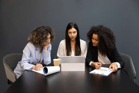 Successful business women sitting in a desk during a meeting and using a digital tablet.の写真素材