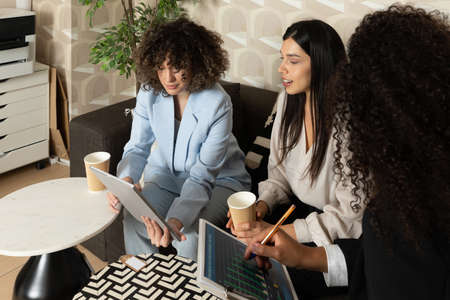 Happy business women sitting in a couch in the office and working together. Office concept.の写真素材