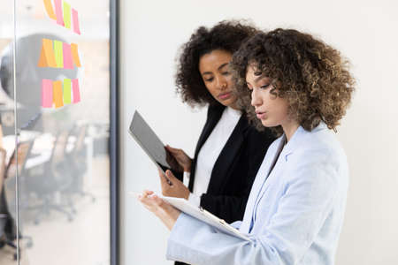 Multicultural coworkers using white board and doing brainstorming together. Co-working conceptの写真素材
