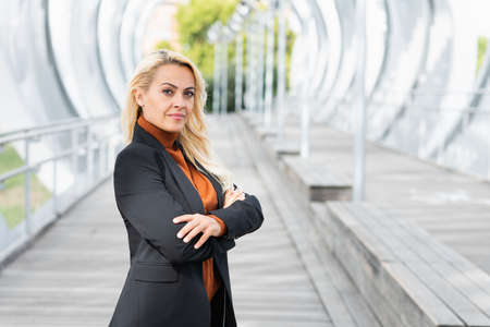 Portrait with copy sapce of a businesswoman posing with the arms crossed while facing the cameraの写真素材