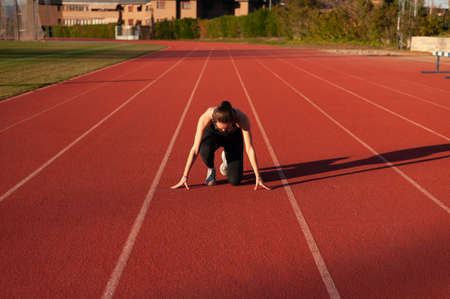 young sportsman on the running track doing stretching and exercisesの写真素材