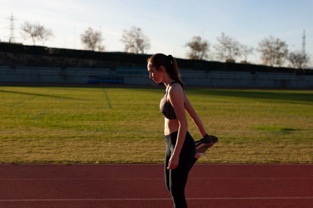 young sportsman on the running track doing stretching and exercisesの写真素材