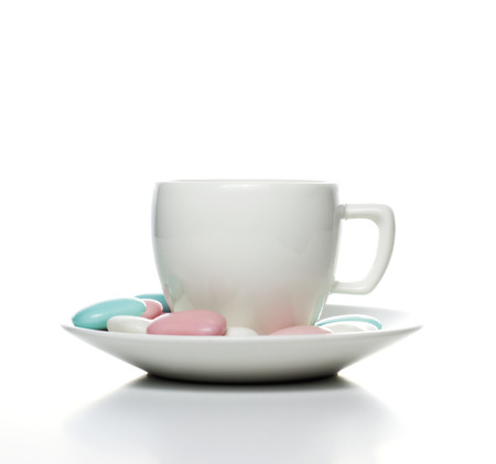 white cup with candies on white backgroundの写真素材