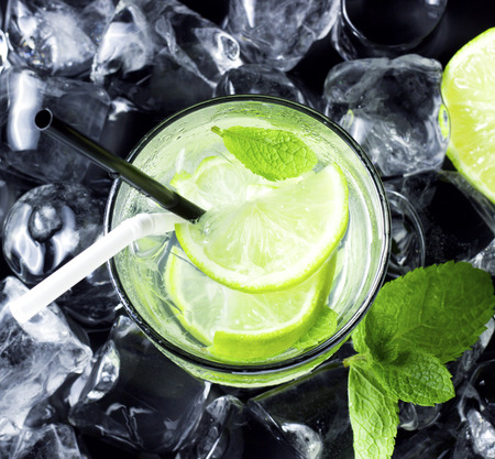 Mojito cocktail with fresh limes, mint and ice on black tableの写真素材