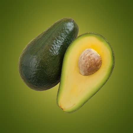 Split avocado pieces viewed from above with glowing green background.の写真素材