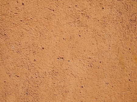 Terra cotta orange cement or stucco wall in bright sunlight.の写真素材