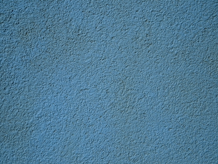 Roughly textured turquoise stucco wall in sunlight.の写真素材