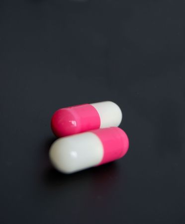 drugs or vitamines? two capsules on blackの写真素材