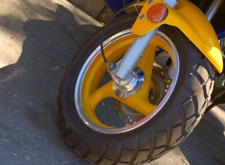 closeup of scooter wheel of yellow colorの写真素材