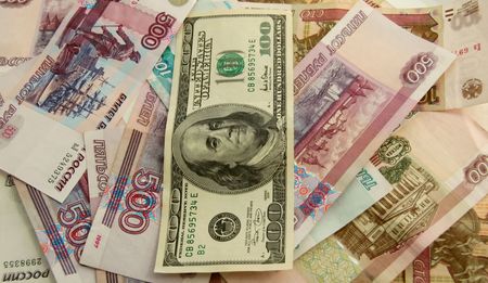 World domination of dollar. Dollar over foreign money. Close-up set of US dollars and Russian roublesの写真素材