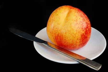 fresh peach on white saucer and knifeの写真素材