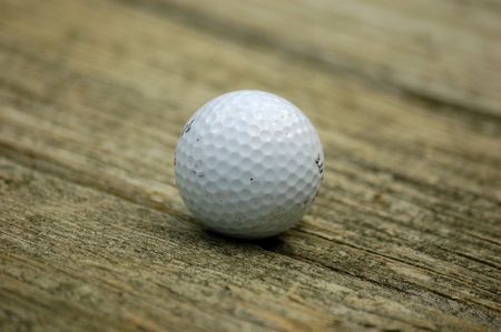 A white golf ball on a aged plankの写真素材
