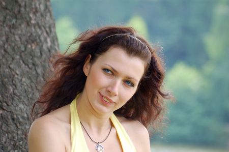 pretty blue-eyed brown-haired typical russian girl near treeの写真素材