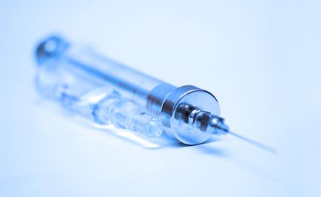 vintage glass syringe and row of medical ampullas toned in blueの写真素材