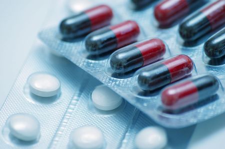 macro of packs of capsules and pills toned in blue