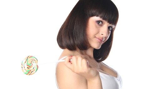 closeup of brunette with rainbow lollipop isolated on whiteの写真素材