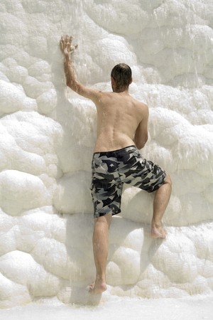 rock climbing - the man is climbing white rock in waterfallの写真素材