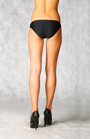 legs of sexy  girl in black panties on gray backgroundの写真素材