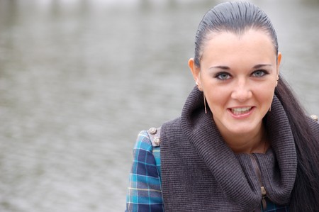 young pretty black haired girl outdoors near pondの写真素材