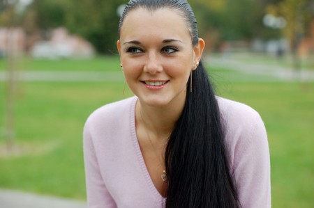 young pretty black haired girl outdoors in autumn parkの写真素材