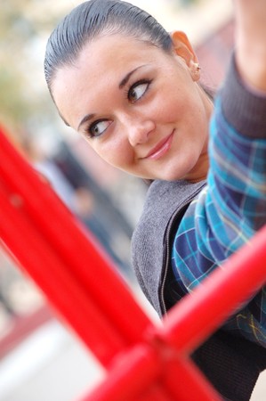 young pretty black haired girl outdoors in autumn on playgroundの写真素材