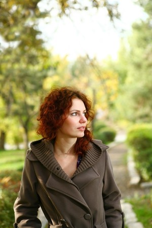 Portrait of a redheaded girl near a tree (autumn colors).の写真素材