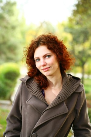 Portrait of a redheaded girl near a tree (autumn colors).の写真素材