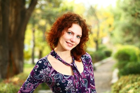 Portrait of a redheaded girl near a tree (autumn colors).の写真素材