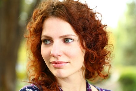 Portrait of a redheaded girl near a tree (autumn colors).