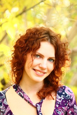 Portrait of a redheaded girl near a tree (autumn colors).の写真素材
