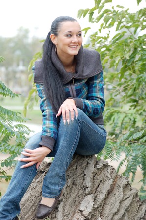 young pretty black haired girl outdoors in autumnの写真素材
