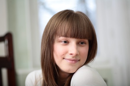 Portrait of a relaxed young woman smiling  in the living roomの写真素材