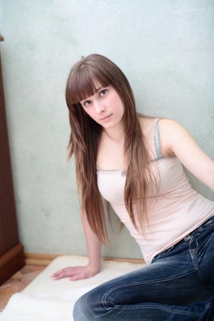 Portrait of a relaxed young woman smiling  in living room on the floorの写真素材