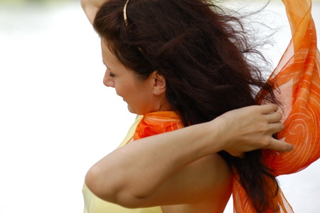 summer - beautiful female outdoors in the park in orange scarfの写真素材