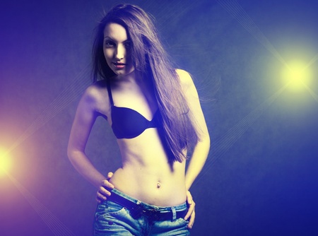 Sexy young self- confident brunette dancing in discolight