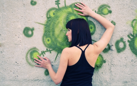 brunette girl posing against concrete wall with graffitiの写真素材