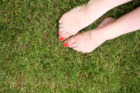 bare legs of the women laying on green grassの写真素材