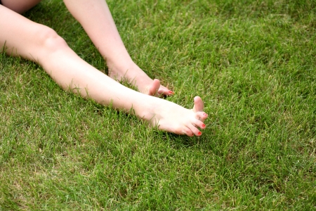 Womans bare feet on the fresh green grassの写真素材