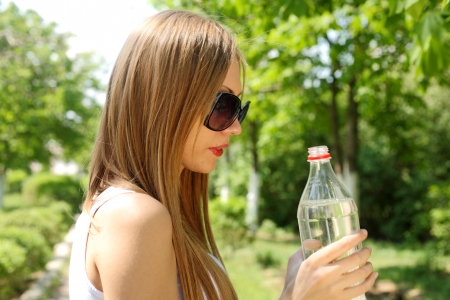 Profile of beautiful woman going to drink some water  fron plastic bottle after workoutの写真素材