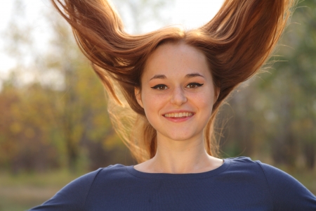 Young redhead woman in the park having funの写真素材