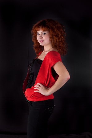 beautiful red hair woman in red dress on blackの写真素材