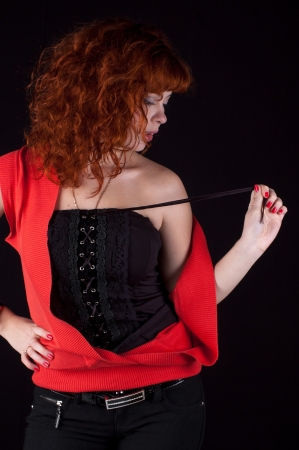 Portrait of beautiful redhead girl on black backgroundの写真素材