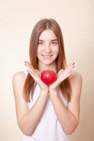 Beautiful blonde woman holding a red apple - health concept. Pretty smile deep blue eyesの写真素材