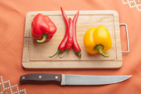 Red peppers on wood with knife (chilli sliced)の写真素材