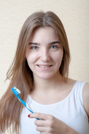 Dental Hygiene Concept - A head and shoulders view of a blond woman with teeth brushの写真素材