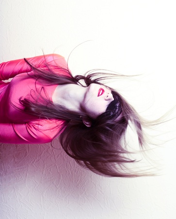 Sexy girl in black mask head and shoulders shot in pink party dress on beige background. Party costume conceptの写真素材
