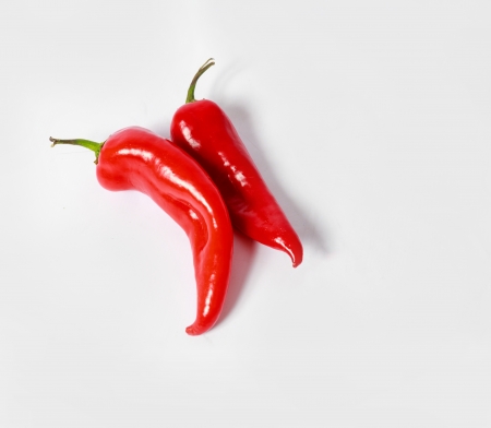two red hot chili peppers on white background